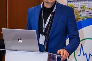 Mówca przy mównicy z laptopem.